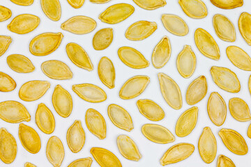Dried pumpkin seeds in husks. Yellow pumpkin seeds on a white background. Isolated. Flat oval seed of squash. Edible seed of a pumpkin. Healthy food. Natural product. Roasted snack. Pepita. Close-up