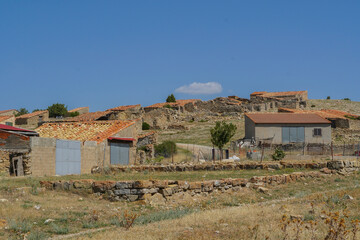 Aldea agrícola semi abandonada en tierras de Teruel, Aragón, antiguas edificaciones de piedra para ganado y útiles de campo de siega y recolección © Tonikko