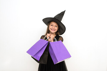 sales, seasonal sales. Fashion. a girl with long dark hair in a witch hat and bags in her hands. A Halloween party. Happy Halloween. The concept of celebrating the autumn