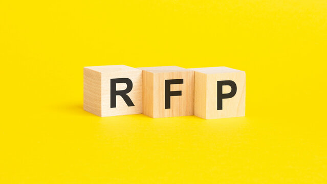 wooden blocks with text RFP on yellow background. business concept