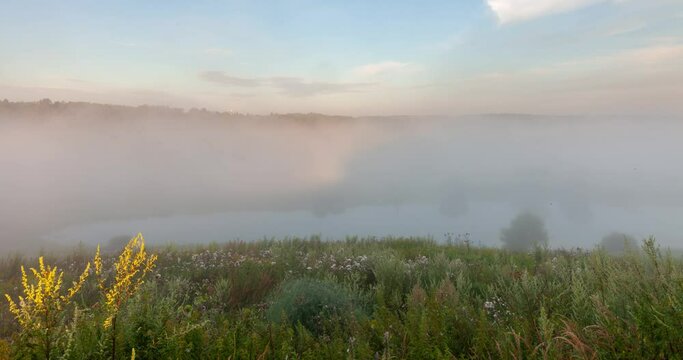 Zeitraffer Aufnahme uaf einen Fluss mit Nebel
