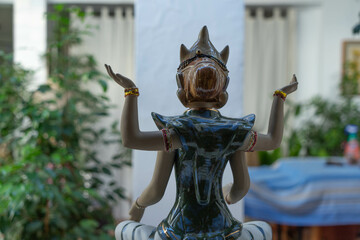 Divinidad oriental de cuatro brazos, en porcelana