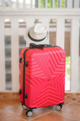 Red suitcase with white hat and glasses