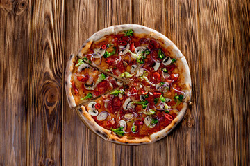 Vegan pizza with tomato sauce, cherry tomatoes, mushrooms, broccoli, red onion on woden background. View from above