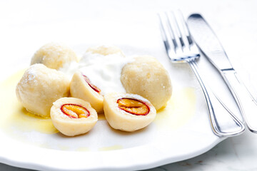 plum dumplings with sour cream, powder sugar and melted butter