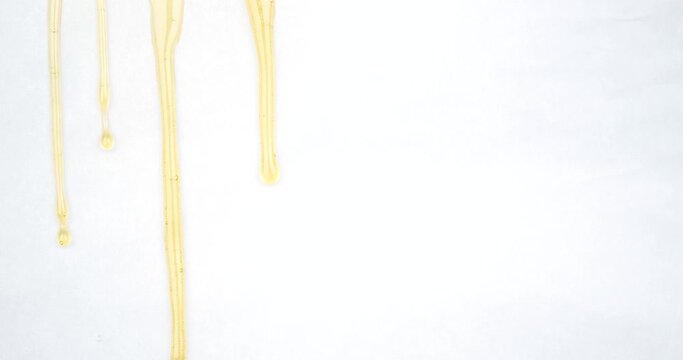 dripping drops of golden cannabis wax, marijuana extract rosin on a white background. High quality 4k footage