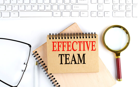 EFFECTIVE TEAM text in the office notebook with keyboard, magnifier and glasses , business concept