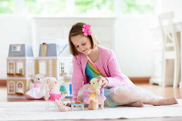 Obraz na płótnie Canvas Little girl playing with doll house. Kid with toys
