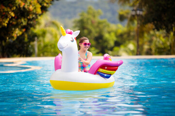 Child on unicorn float in swimming pool. Kids swim © famveldman