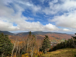 Vermont Valley in Autumn under the puffy clouds nestled into the moutains