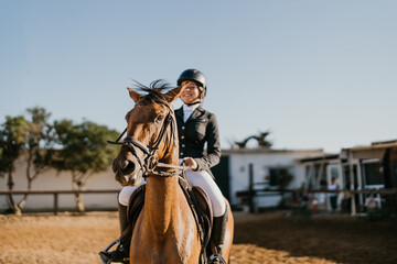 Obraz premium brown horse ridden by female rider out of focus