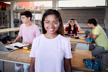 Portrait of a girl standing in a technology class looking at the camera. Vocational training...