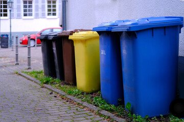 row of plastic garbage container, in Germany, garbage collection in designated place, environmental concept, different types of garbage into different bins, environmental protection, waste recycling
