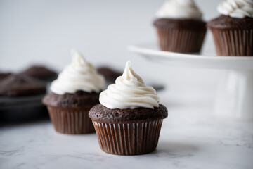 chocolate cupcake with white icing on white background