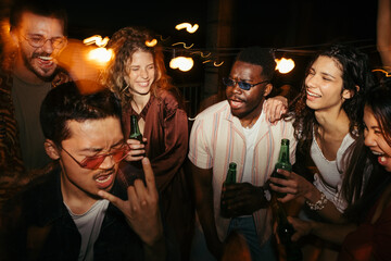 A group of friends is having a good time at the open-air party on the rooftop.
