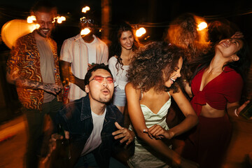 A playful group of friends is having a great time at the rooftop nightclub. - 526390966