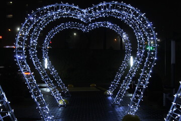 New Year's Christmas light with illuminated tunnels corridor in the park. Festive Christmas lighting. Holiday atmosphere. Decoration