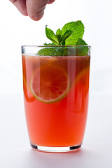 Red jumbo mug contains warm tea and limes. Tea spices