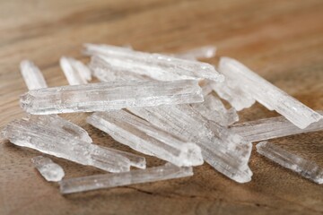 Menthol crystals on wooden background, closeup view