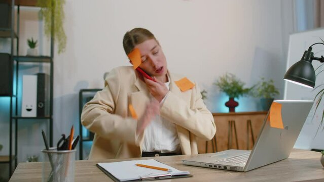 Tired exhausted businesswoman in suit working on laptop at office with many sticker task inscriptions. Freelancer woman busy occupation feels sad boredom overworked multitasking. Panic attack deadline