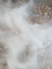 Pellets in a hopper of a smoker/grill with smoke flowing out