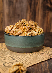 walnut in ceramic bowl on kitchen wooden table