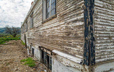 Wood siding falling off an abandoned building in southern Idaho, USA