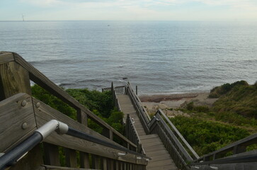 wooden steps over the ocean leading to the water, stunning view and bluffs, block island, rhode island