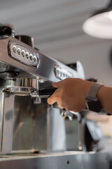 Hand working on coffee machine with blur cafe background 