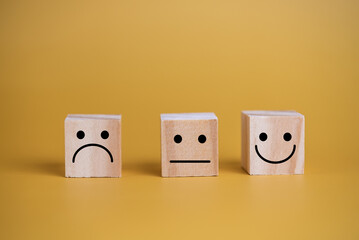 Customer service and Satisfaction concept happy Smiley face icon.Business feedback positive rating very impressed wood cube on table.