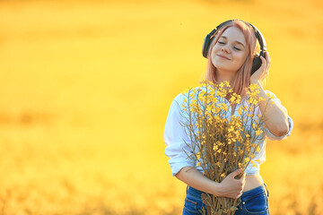 audio headphones summertime girl music in a field of flowers, young female spring