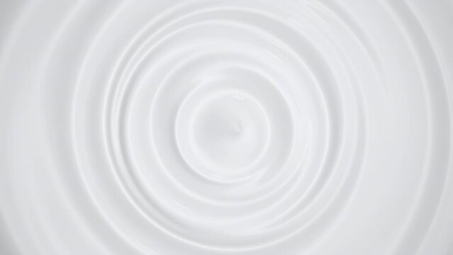 Top view Closeup slow motion Milk cream swirl clean ripple. Motion texture concept for food and drink , cosmetics concept idea. 4K animation. Selective focus.