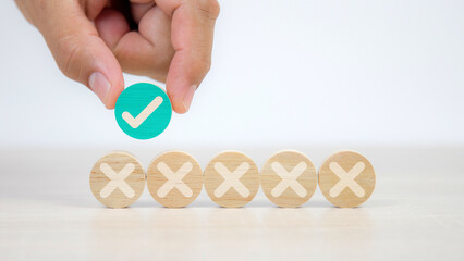 Hand choose check mark on wooden circle shape with cross symbol for true or false changing mindset...