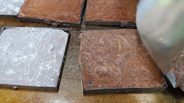 (Thai Call) Khanom babin. Coconut macaroon or coconut pancake, traditional Thai dessert cooking on the big square shape pan. sale at the thailand market