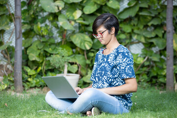 Young beautiful Indian teenager girl working on a laptop wearing casual t-shirt and spectacles, Asian adult female using computer. cloud computing and it professional, web development.