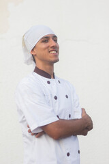 Young Chef smiles at camera on white background space for design