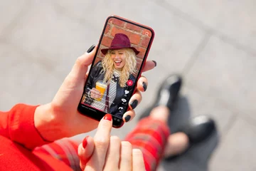 Frau, die Social-Media-Inhalte auf dem Handy ansieht © Kaspars Grinvalds