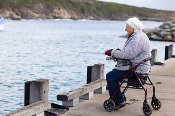 person with mobility issues sitting on wheeled walker while fishing off Bremer Bay jetty