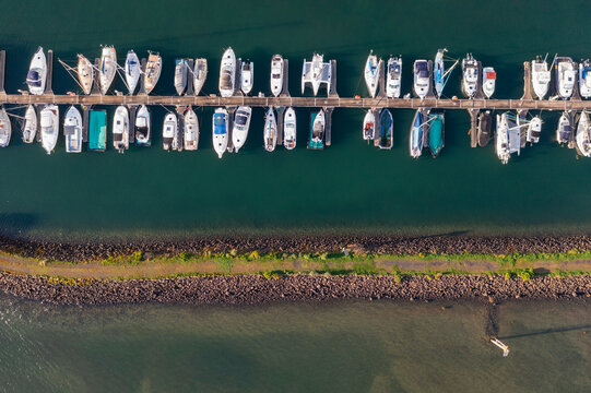 Aerial view of a boats and yachts lined up along jettys at a marina