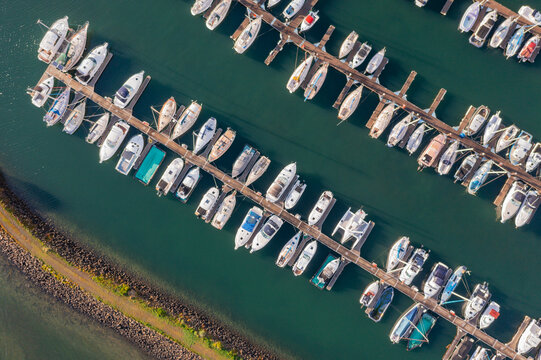 Aerial view of a boats and yachts lined up along jetties at a marina