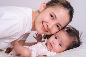 Fototapeta na wymiar Portrait of happy mother and baby. Happy mom smile with family and love newborn.