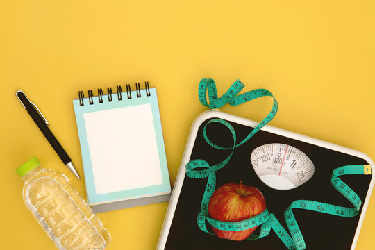 close up Weight scale and a measure tape with fresh apple , Healthy diet for weight loss control planing concept