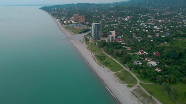 Black Sea beach and embankment with vacationers and infrastructure. Drone flight over Ureki.