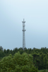 telecommunication tower with antennas over the trees