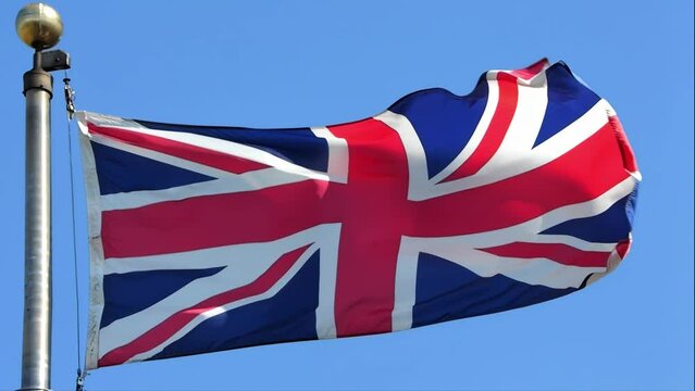 A slow-motion of a waving United Kingdom flag during a sunny day.