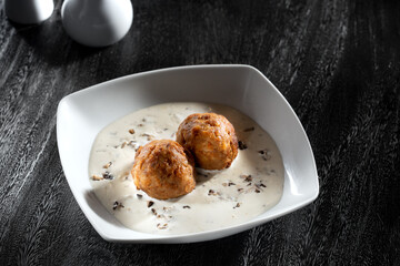 Close up view of meatballs in creamy sauce on grey back 