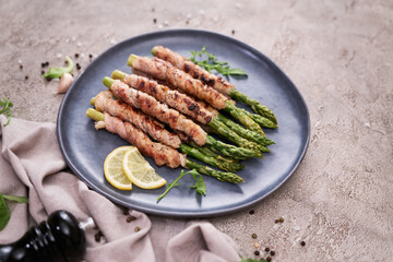 Healthy food - Asparagus wrapped with bacon and spices on a plate