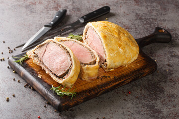 Delicious freshly cooked beef wellington with mushroom duxelle and puff crust close-up on a wooden...