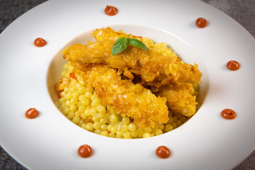 Recipe for chicken tenders with corn flakes and Italian Piombo pasta risotto and peppers. High quality photo