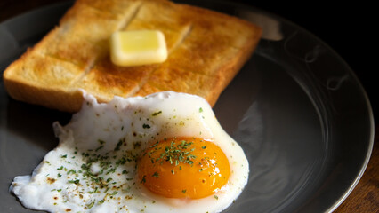 爽やかな朝日を浴びながらたっぷりのバターと目玉焼きでいただくトーストの朝食で一日の活力を得る